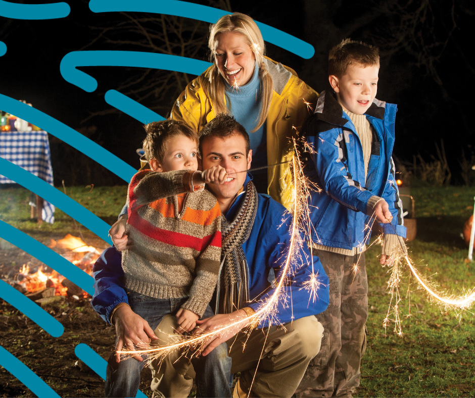 Family picture of mam,, dad and two young boys enjoying bonfire night with sparklers